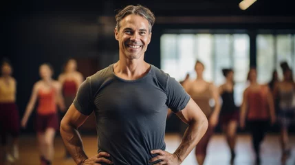 Glasschilderij Dansschool Portrait of a passionate choreographer smiling, with a dance studio and dancers in the background