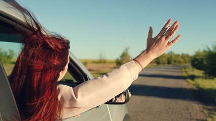 girl rides car with her hand out window, conceptual car journey along road, girl sitting car...