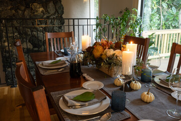 Festive Thanksgiving tablescape, with flowers and lit candles.