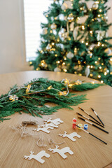 Festive craft supplies, twinkling tree in backdrop