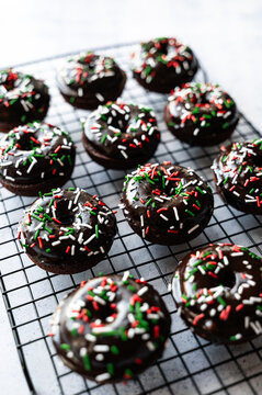 High angle close up of chocolate donuts with Christmas sprinkles.