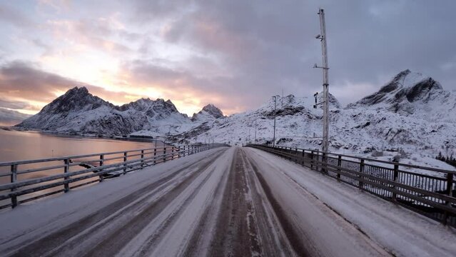 The hum of tires on a winter road in Lofoten, Norway, harmonizes with the tranquil stillness of the snow-covered surroundings, creating a symphony of Arctic travel.