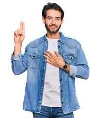 Young hispanic man wearing casual clothes smiling swearing with hand on chest and fingers up,...