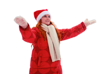 Adult woman in a santa hat throws snow on the background of winter trees in the park, isolated on a white background. Red-haired woman on Christmas and New Year Eve walks in the winter in red clothes