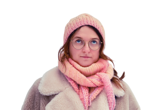 A woman in a white fur coat and pink hat stands in a snow-covered winter forest. Portrait of an adult woman with glasses and a bag among the trees in the park.
