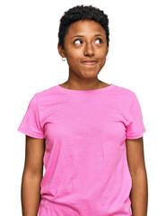 Young african american woman wearing casual clothes smiling looking to the side and staring away thinking.