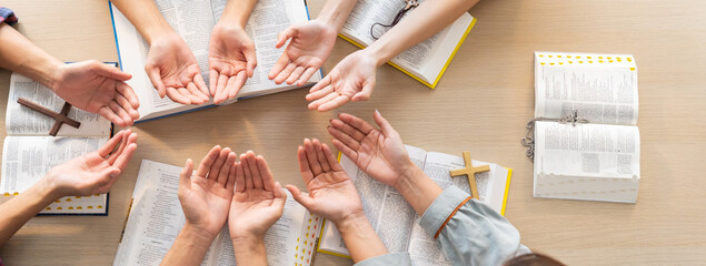 Cropped image of diversity people hand praying together at wooden church on bible book. Group of believer hold hand together faithfully. Concept of hope, religion, faith, god blessing. Burgeoning. - obrazy, fototapety, plakaty