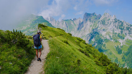 Fototapeta na wymiar Asian women hiking in the Swiss Alps mountains during summer vacation with a backpack and hiking boots. woman walking on the Saxer Lucke path in Switzerland during summer