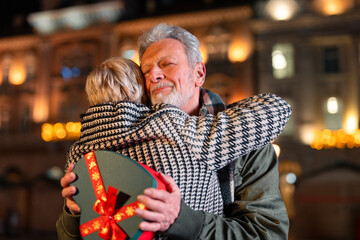Grateful senior man touched by a gift from a woman. Senior woman showing love and affection to a...