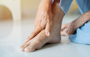 Cropped shot of an unrecognizable man suffering with foot cramp in the room.