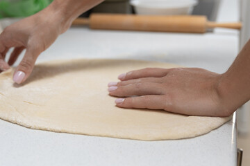 Girl rolling out dough in the kitchen