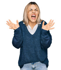 Young caucasian woman wearing casual clothes celebrating mad and crazy for success with arms raised...