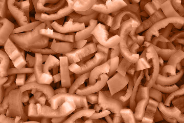 Texture slices of chopped green bell pepper. Peach fuzz is color of year 2024 tinted image