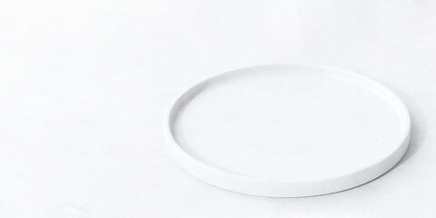 Modern round white concrete plate shape podium on table counter in sunlight for luxury organic...