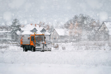 Tractor with mounted salt and sand spreader, road maintenance - winter gritter vehicle. Municipal service melting ice and snow on streets. Diffusing salt blend on  public roads.