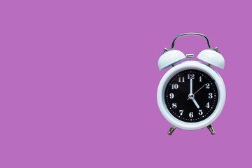 Retro alarm clock on pink background. five o'clock