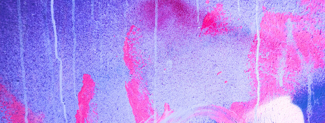 Messy paint strokes and smudges on an old painted wall. Pink, purple, white color drips, flows, streaks of paint and paint sprays