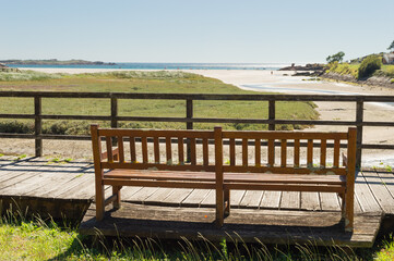 Naklejka na ściany i meble wooden bench facing the sea