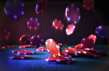 Red casino betting chips falling on felt mat