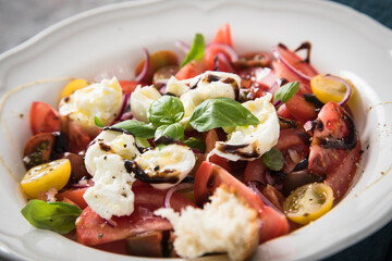 Italienischer Burrata Käse Salat mit bunten roten und gelben Tomaten, Basilikum, Olivenöl und...