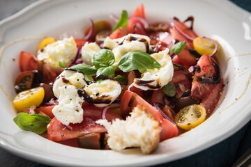 Italienischer Burrata Käse Salat mit bunten roten und gelben Tomaten, Basilikum, Olivenöl und...