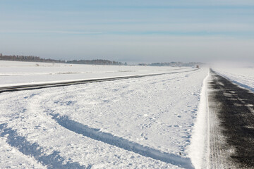 Obraz premium A snowy taxiway at a small local airport on a sunny winter day.