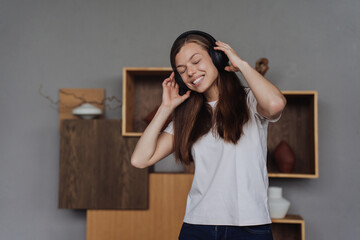 Adorable Caucasian student girl having break of remote learning listening music using headphones. Happy people, active leisure.Youth.