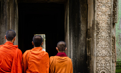 Three Unrecognizable Buddhist Monks Dressed With Orange Robes In Angkor Wat, Siem Reap, Cambodia