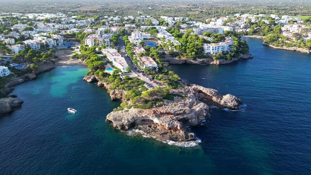 Tropical paradise turquoise bay. Beautiful Mediterranean cave rocky sandy beach with blue water on a sunny day in Majorca, Spain. Famous tourist attraction Cala d'Or Beach, Mallorca, Balearic Islands