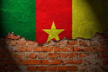 A wall with a painting of the cameroon flag at night.