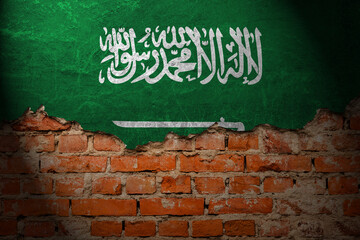 A wall with a painting of the saudi arabia flag at night.