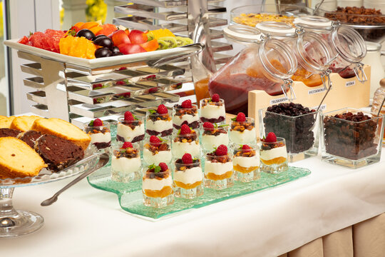 Lavish dessert buffet spread with fresh fruit, cakes, and layered parfaits, elegantly presented at a formal event or reception