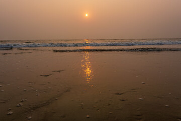 foam of sea or ocean waves against the backdrop of the setting sun