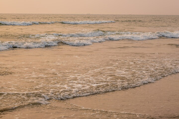 foam of sea or ocean waves against the backdrop of the setting sun
