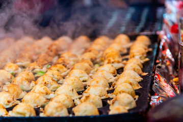Naklejka premium Close up of Takoyaki, famous japanese street food in Takoyaki shop.
