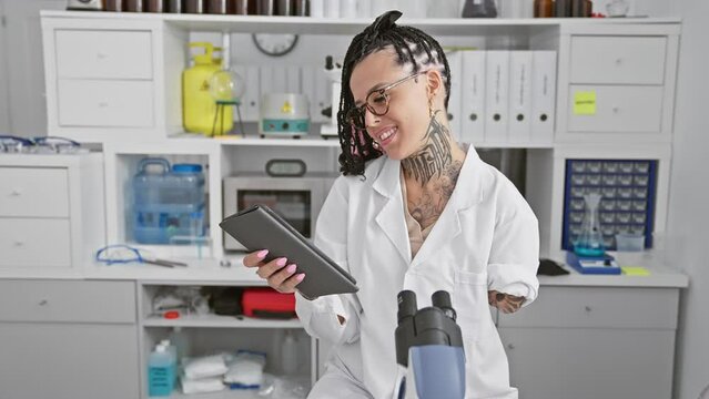 Smiling hispanic amputee woman, confidently mastering her touchpad in high-tech lab