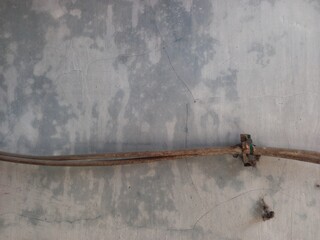 Old electric cable pinned on a wall. Grunge and weathered wall background. 