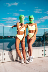 Two beautiful sexy women in green underwear. Models wearing bandit balaclava mask. Hot seductive...