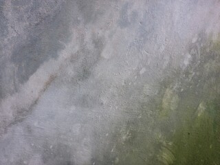 Weathered grey wall with moss. Grunge concrete wall background. Old house wall backdrop. Algae growing on wall.