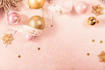 Festive Christmas and New Year background with gold and pink baubles, ribbons and stars. White...