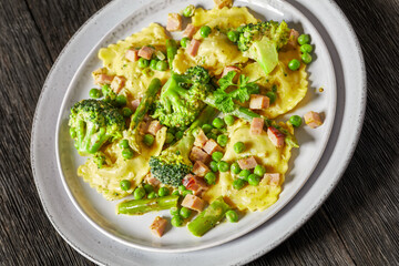 ravioli primavera with ham on a grey plate