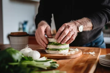 Foto op Canvas man assembling a rice cake with avocado sandwich © primopiano