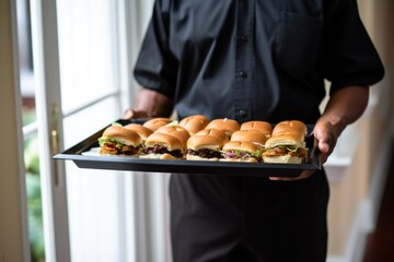 man carrying tray of bbq pork sliders to table