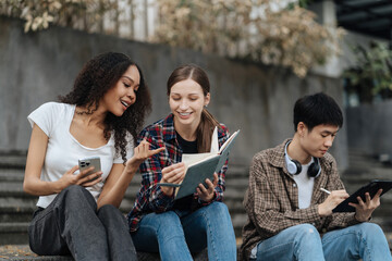 Education knowledge and university concept - group of students reading and preparing for exams on holiday.