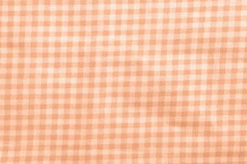 Peach fuzz checkered cotton texture. Fabric textile background