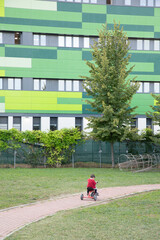 A kid riding a tricycle in a kindergarden playground