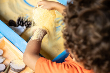 little child playing with sand