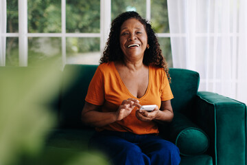Happy black woman enjoying using mobile apps for seniors on her smartphone