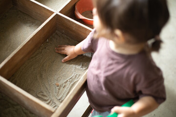 little child playing with sand