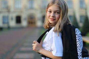 Happy schoolgirl enjoys nature in a park, radiating positivity and beauty, showcasing a cheerful portrait.